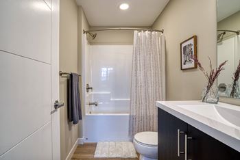 A white bathroom with a toilet, sink, and shower.